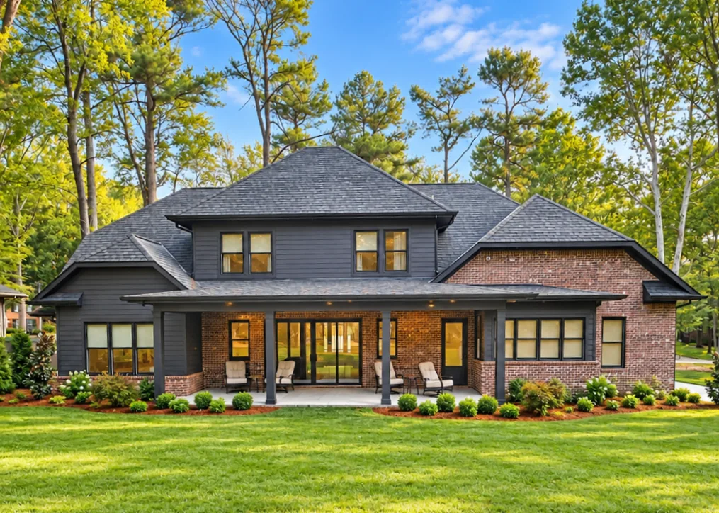 Back of the home with a deep covered porch, outdoor chairs, and glass doors to the living room